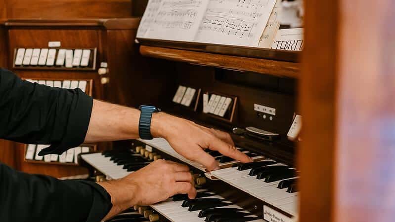 hands playing a pipe organ