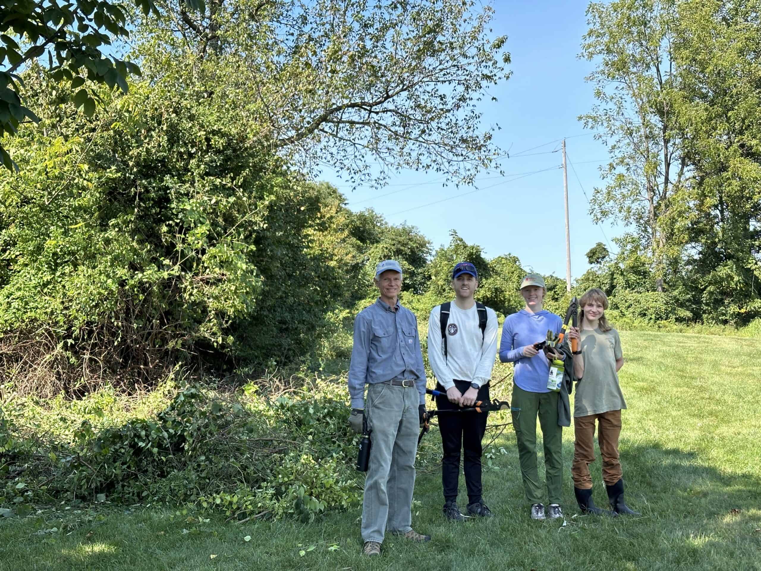 A group of volunteers outdoors posing with tools