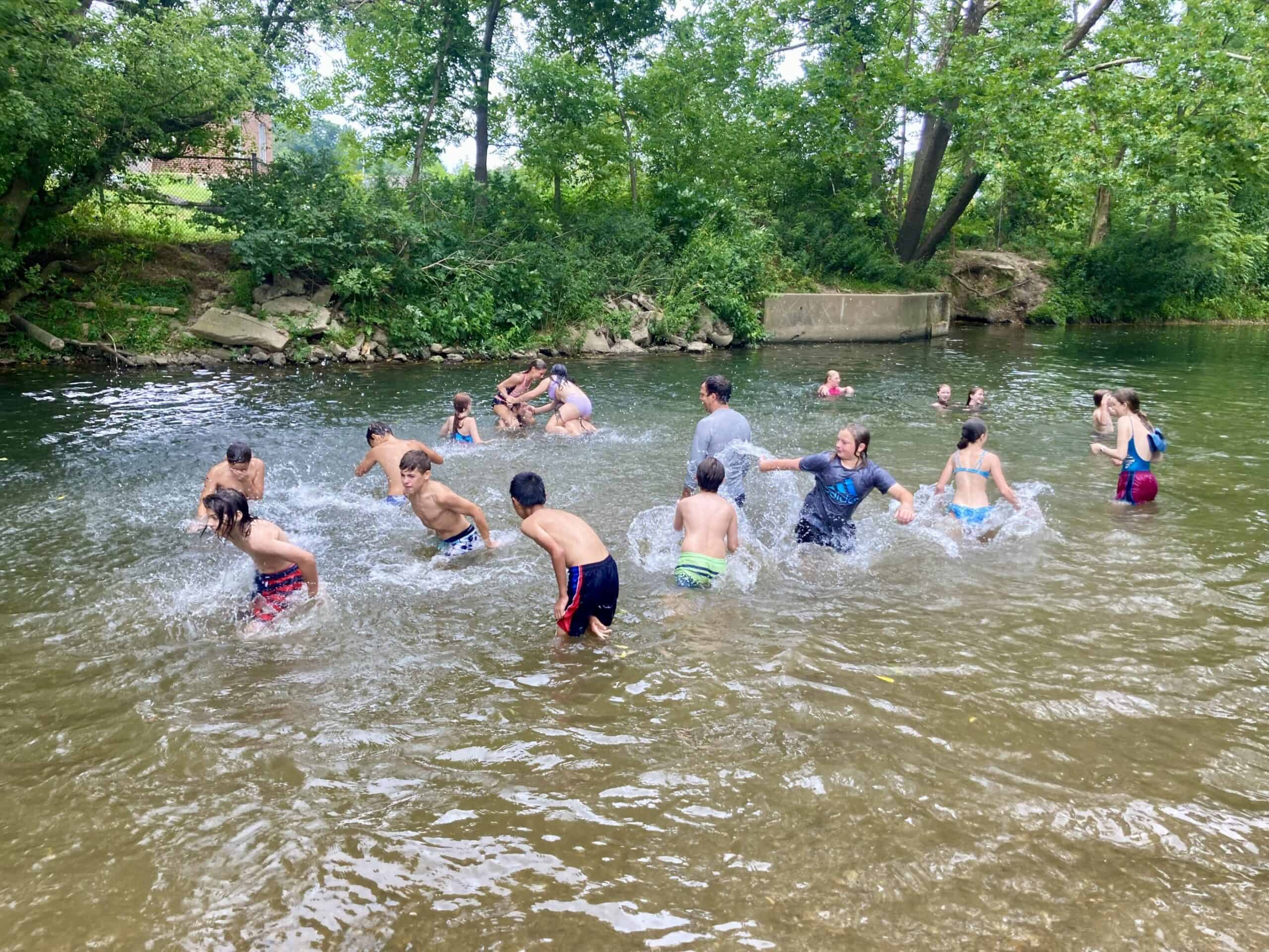 Crow's Nest Camp kids splashing in a creek.