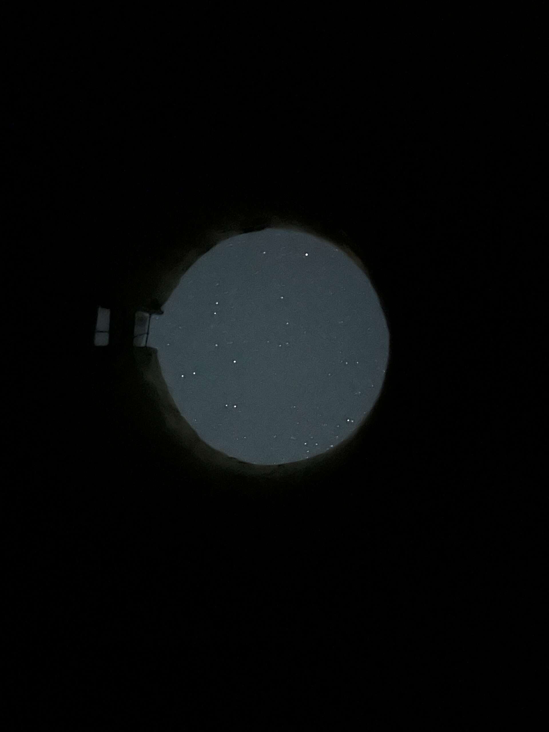 nighttime sky with stars showing through a circular opening in a silo that is temporarily without a roof