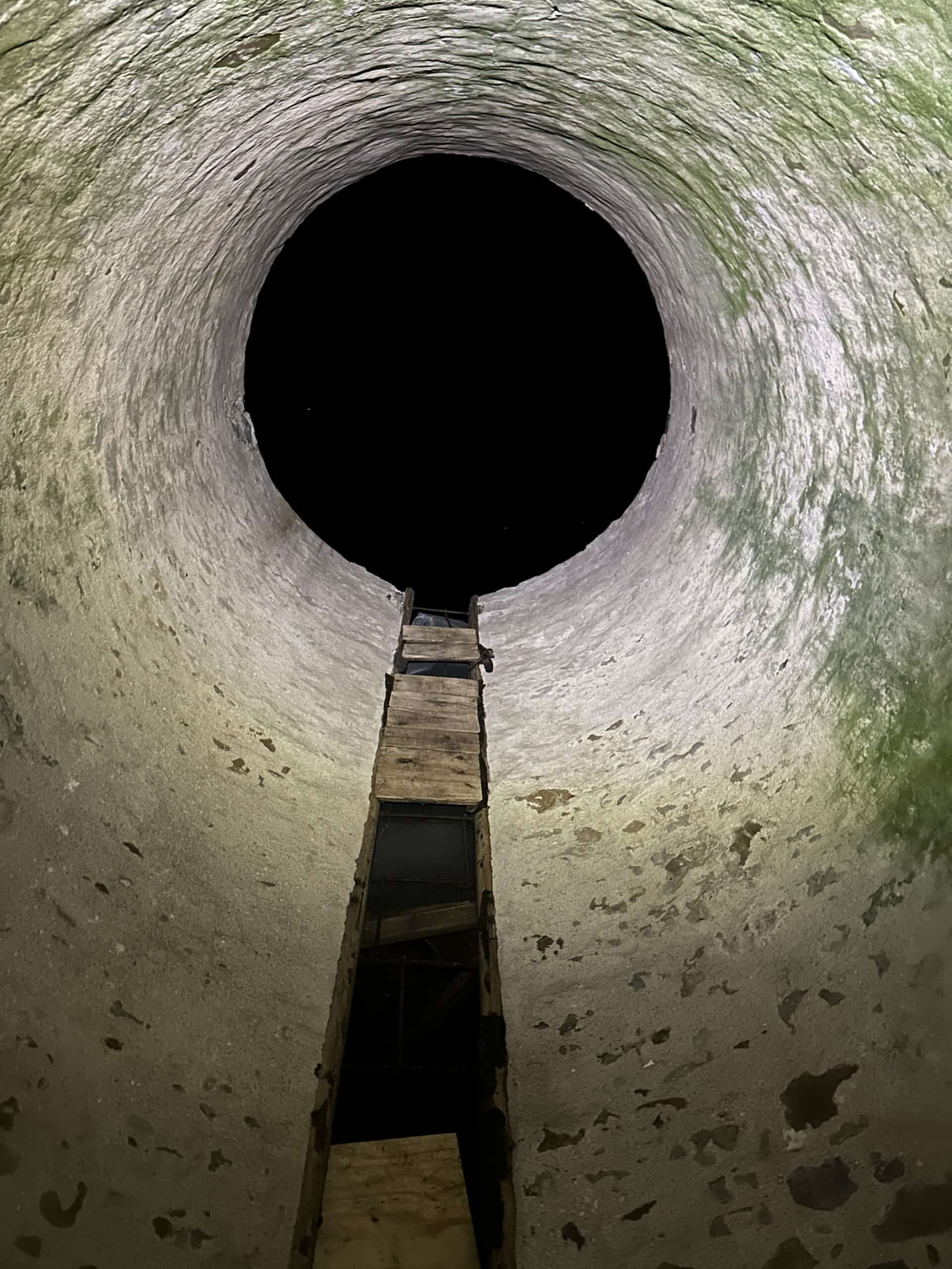 nighttime sky showing through a circular opening in a silo that is temporarily without a roof