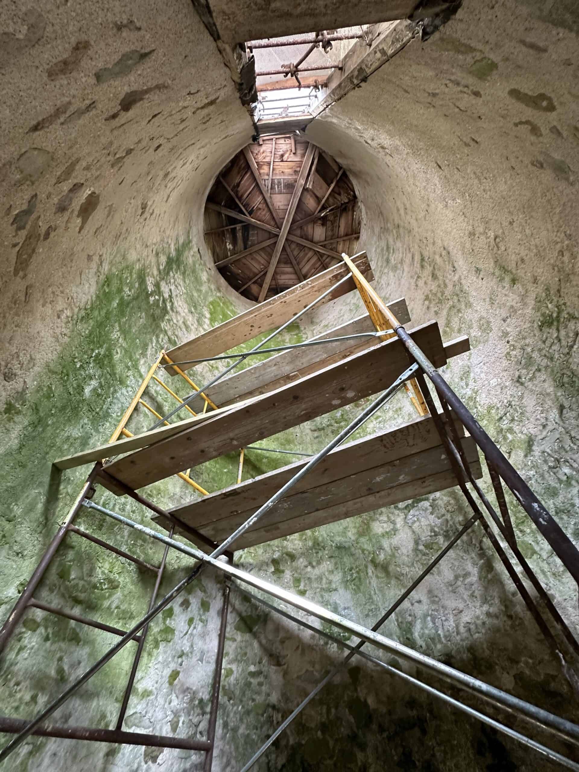 Inside view of a stone silo looking up with scaffolding set up.