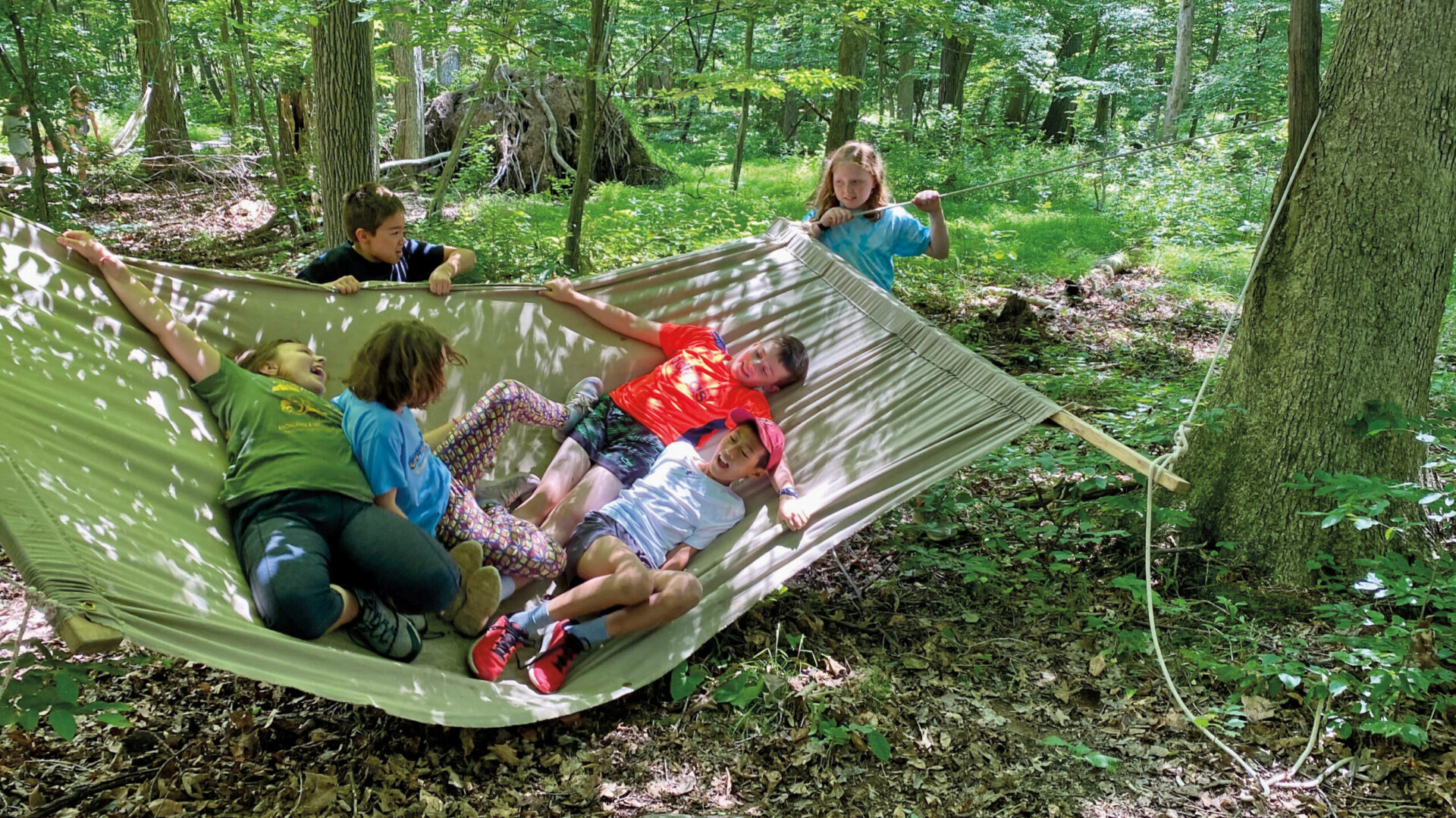 A group of five children play in a hammock at Crow's Nest summer camp