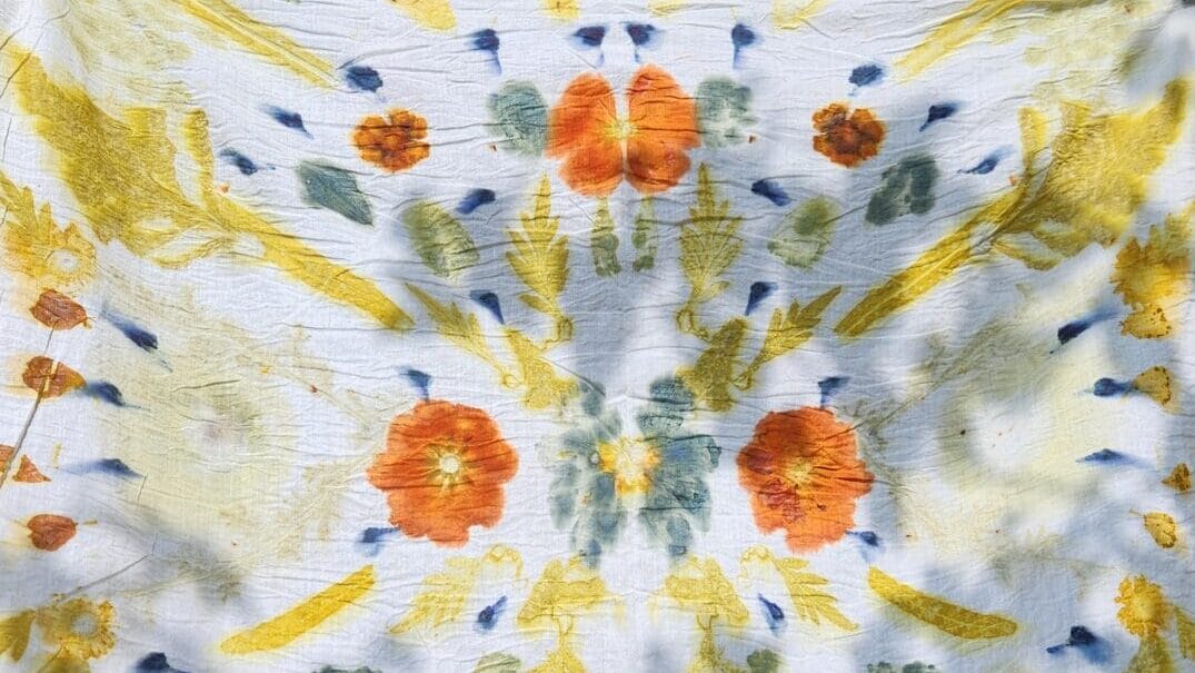 white fabric with naturally dyed patterns using flowers and greenery
