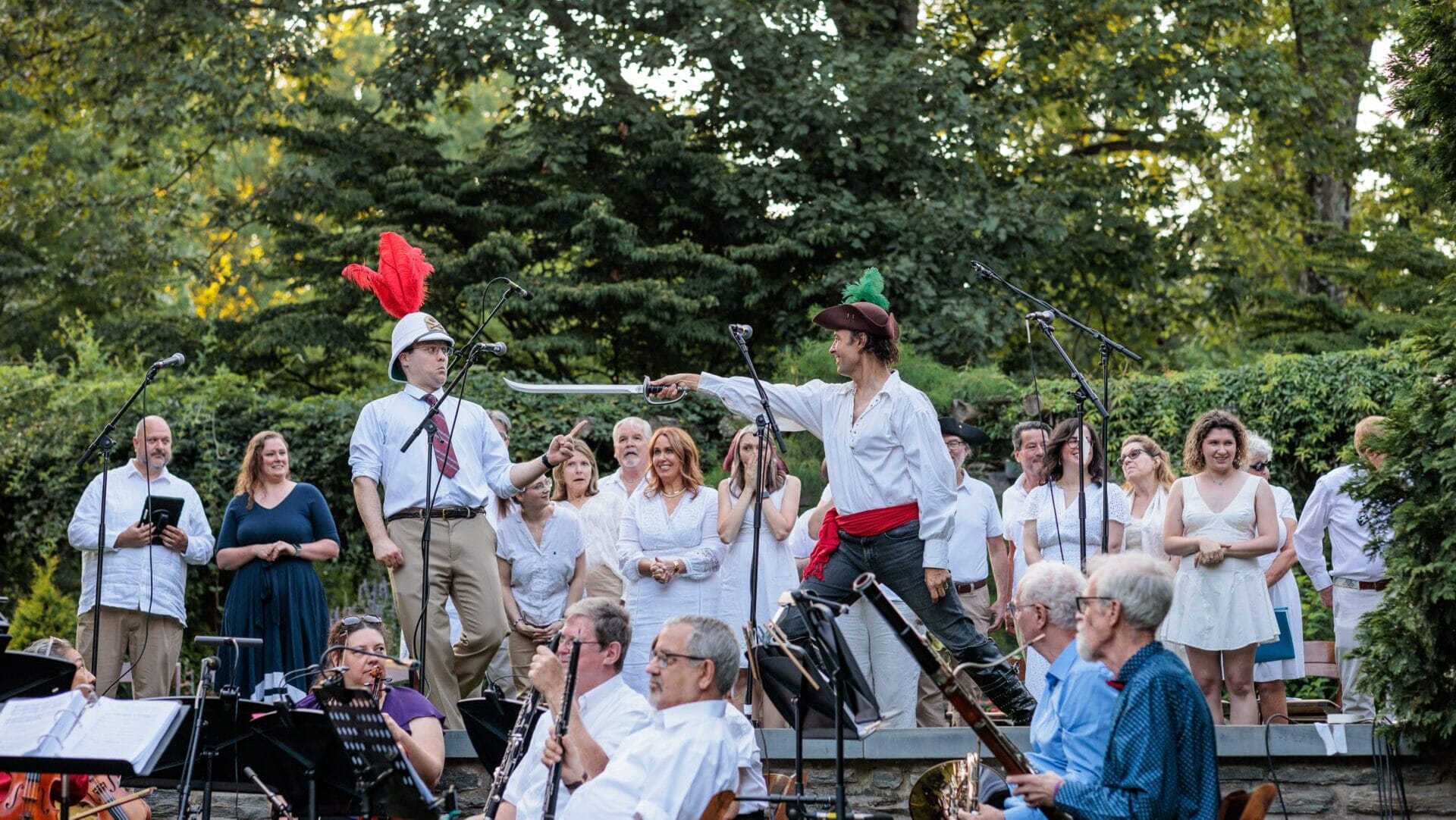 Performers dressed in costume on a stone stage with trees in the background