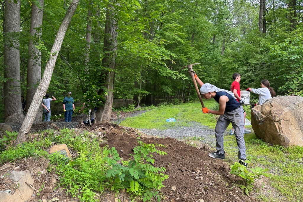 Cadet swinging a pick-mattock to spread soil