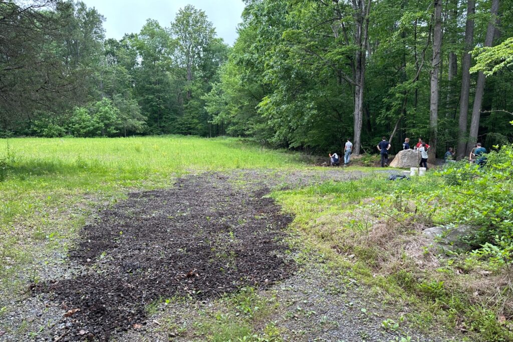 Cadets spreading gravel on a trail.