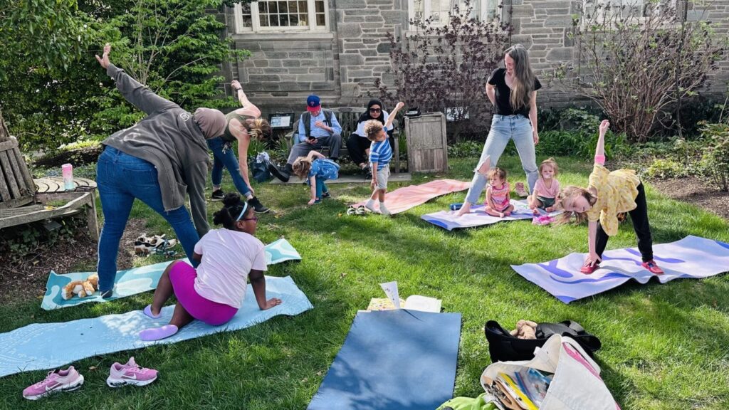 kids and adults doing yoga in a garden