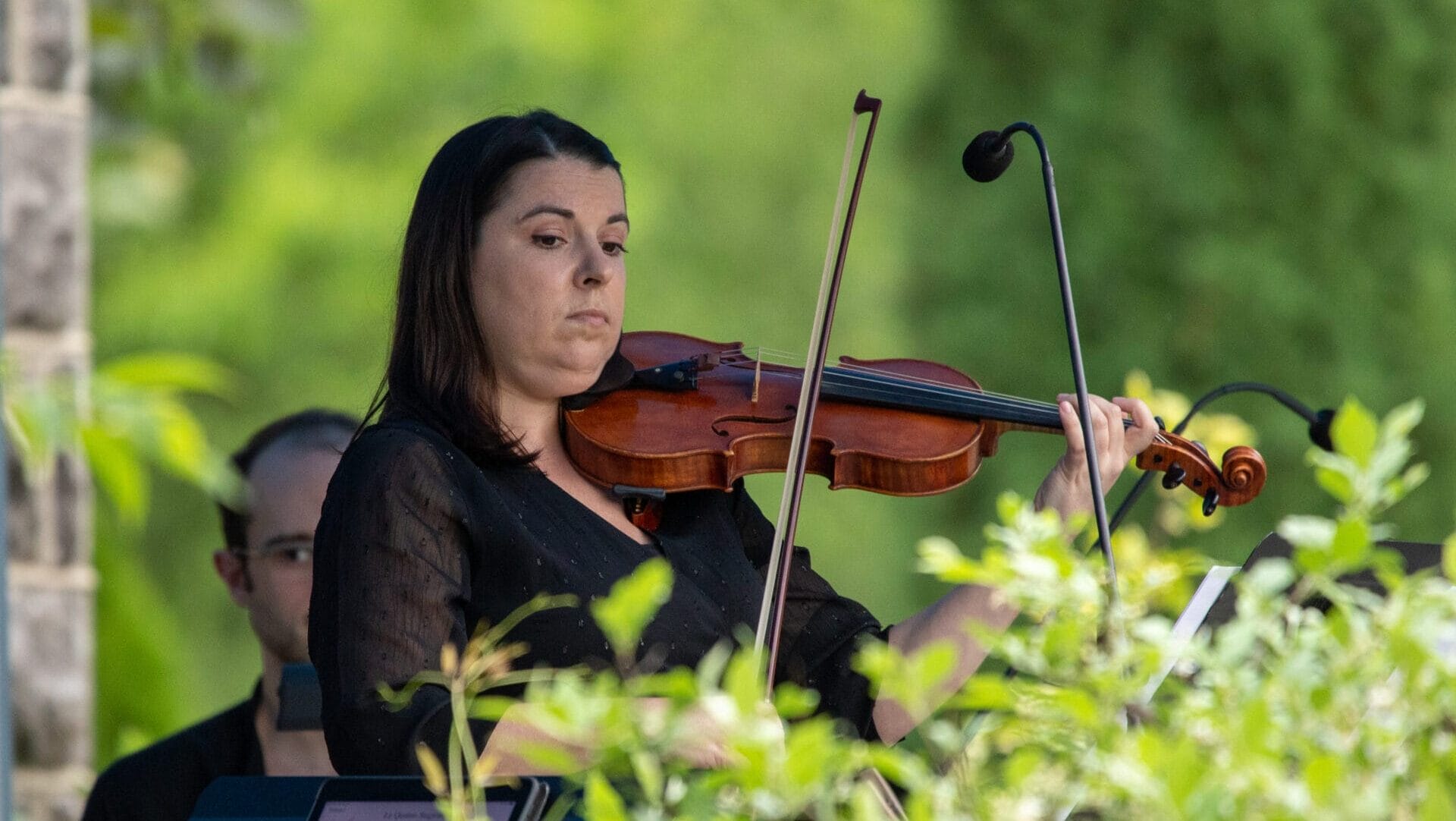 woman playing violin in a garden