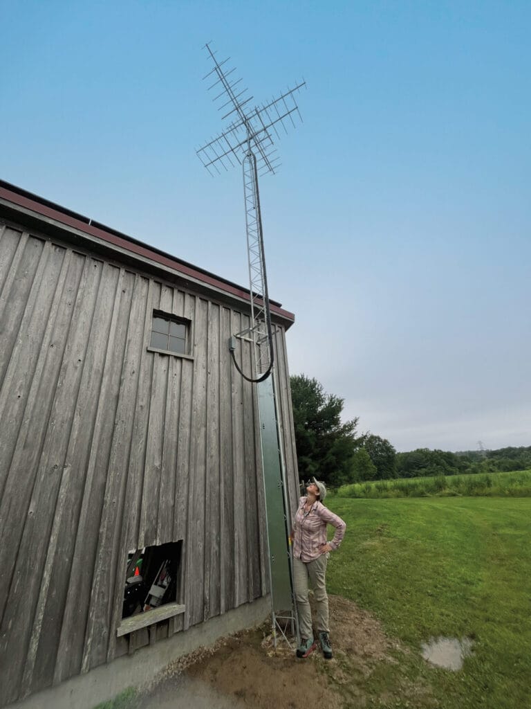 A metal Motus tower affixed to the side of a wood-sided building